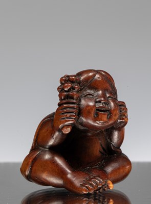 Lot 248 - NETSUKE OF A SEATED CHILD WITH RATTLE