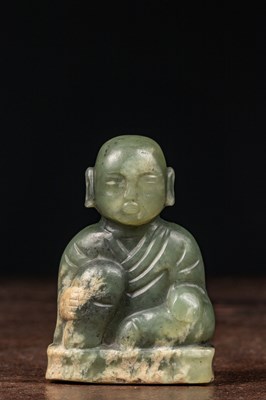 Lot 194 - A JADE FIGURE OF A SEATED BOY CHINA QING DYNASTY 18TH CENTURY