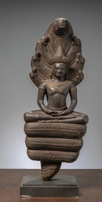 Lot 433 - A DARK STONE NAGA BUDDHA. CAMBODIA. ANGKOR WAT PERIOD. 12TH CENTURY