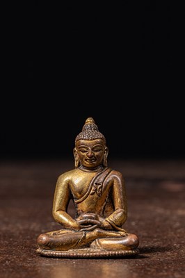 Lot 208 - A SMALL GILT BRONZE FIGURE OF ŚĀKYAMUNI BUDDHA TIBET 15TH CENTURY