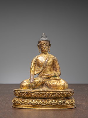 Lot 217 - A SEATED BRONZE BUDDHA, FIREGILT, TIBET, 15TH CENTURY