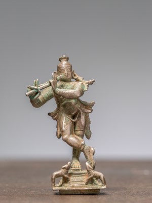 Lot 334 - A KRISHNA PLAYING THE FLUTE, SILVER, INDIA 19TH CENTURY