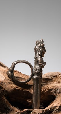 Lot 260 - A RITUAL IRON RING CAST AS A WRATHFUL DEITY, TIBET OR NEPAL, 13TH TO 15TH CENTURY